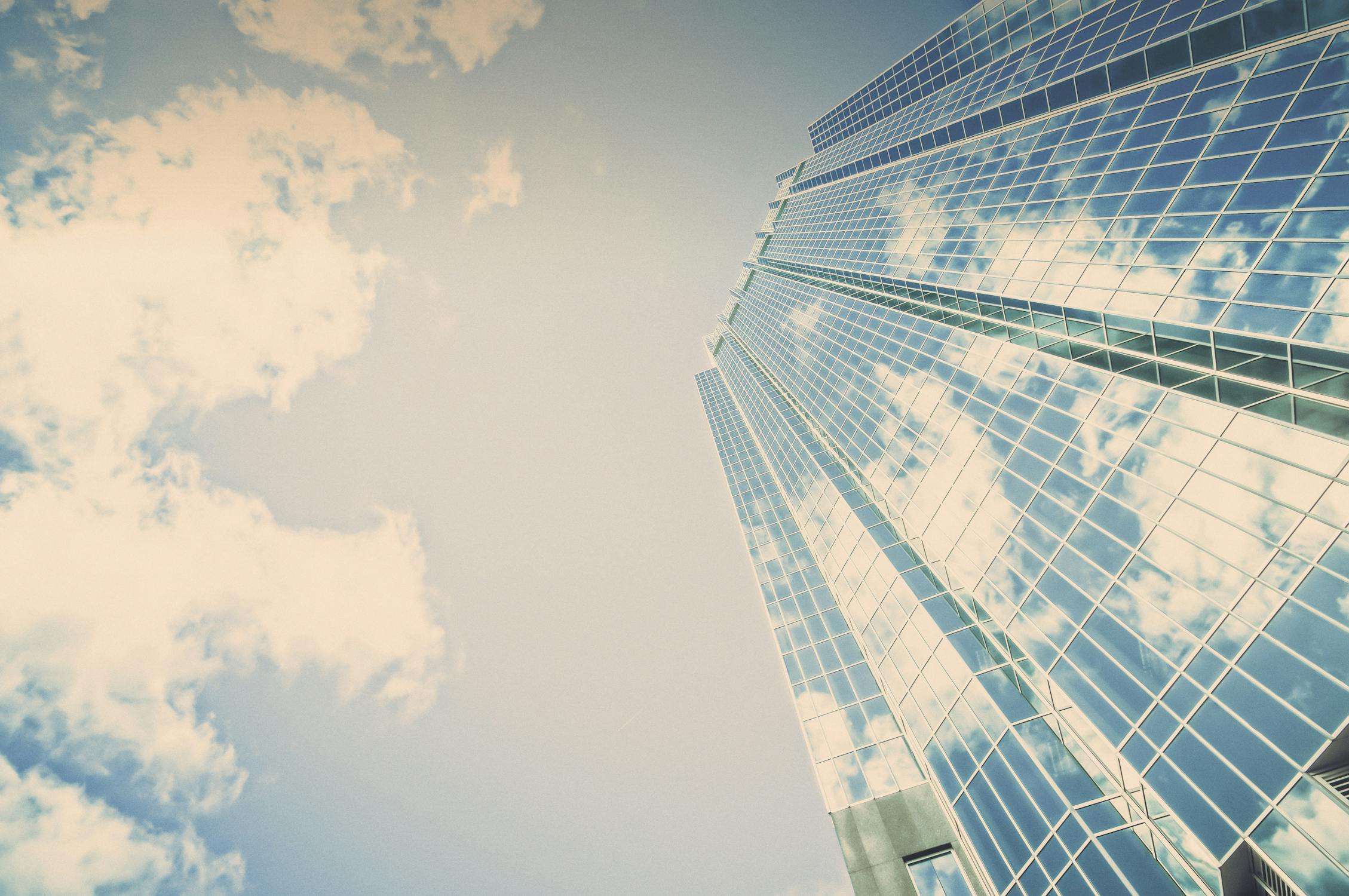 Gratte-ciel de bureaux en verre reflétant ciel et nuages