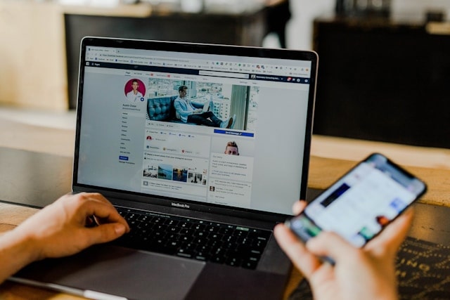 Personne utilisant ordinateur et smartphone, facebook.