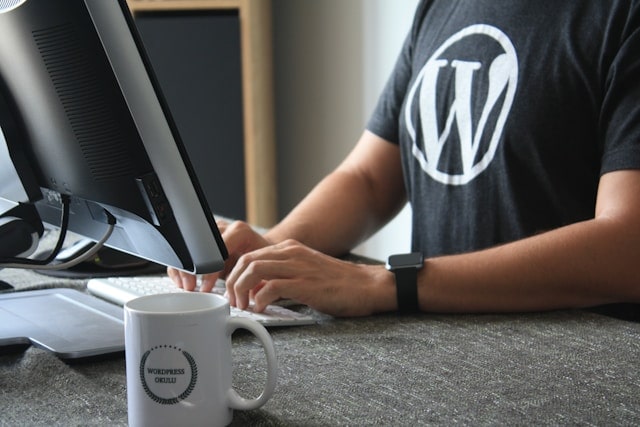 Développeur tapant sur ordinateur avec un t-shirt WordPress